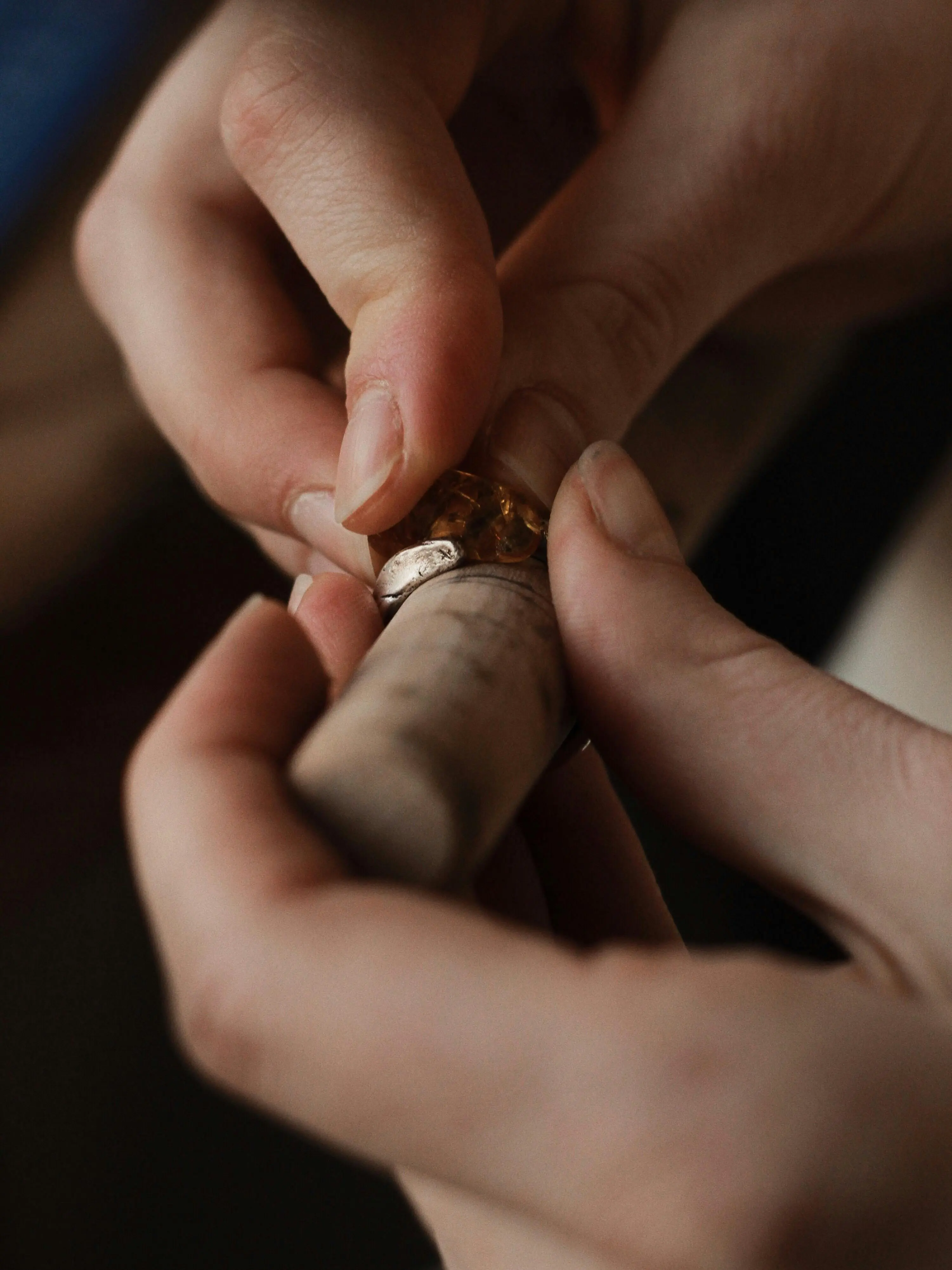 Close-up of artisan hands delicately crafting a gold ring